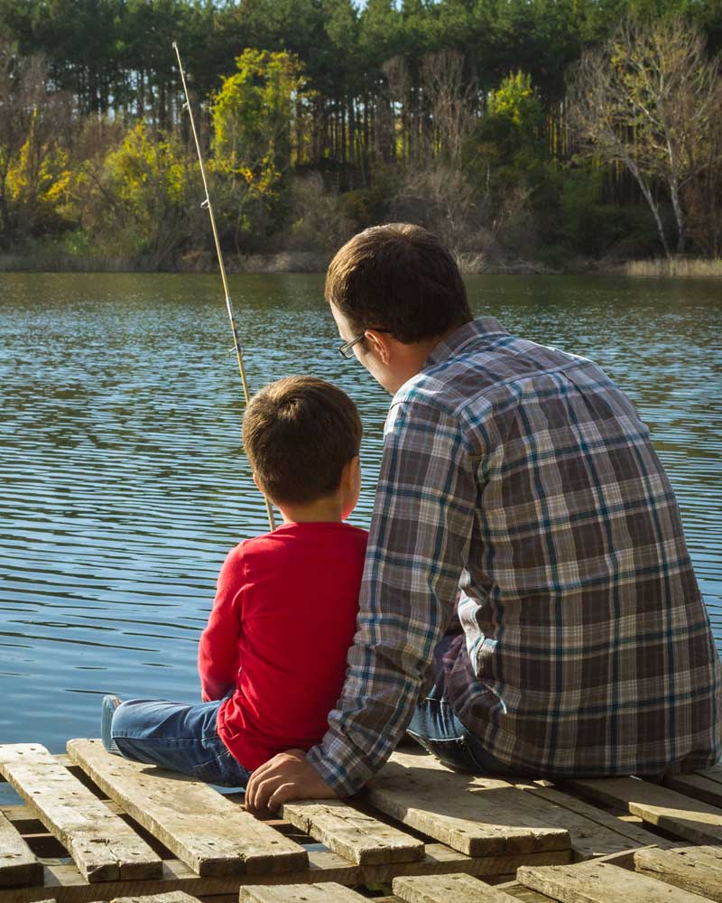 father and son fishing off a pier