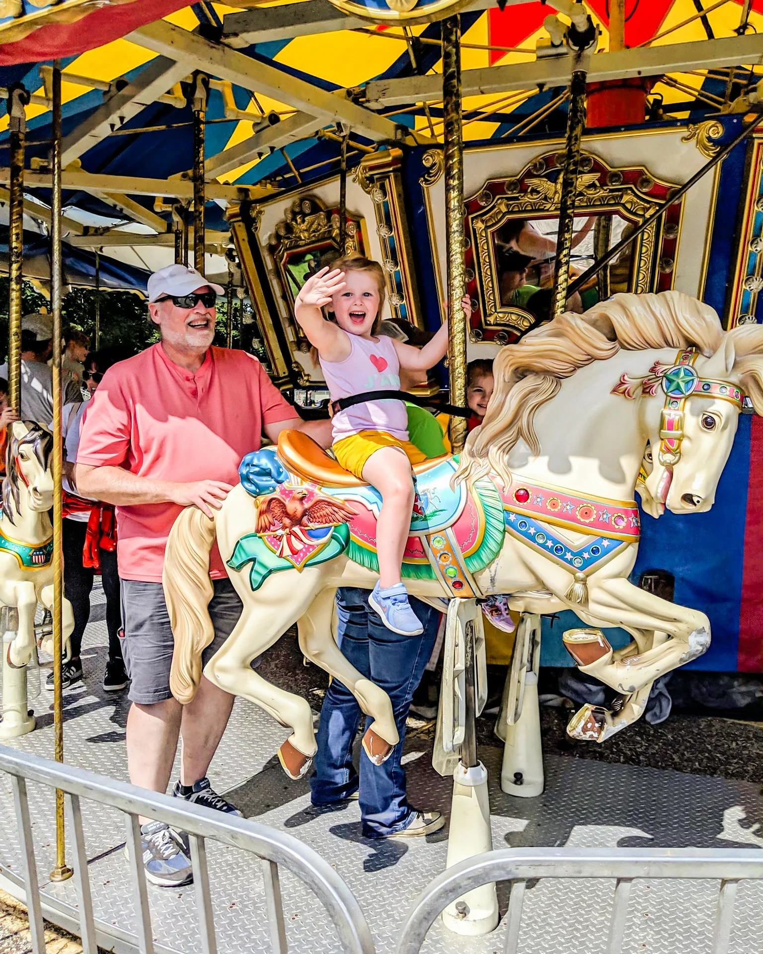 Little girl and her father riding a merry-go-round