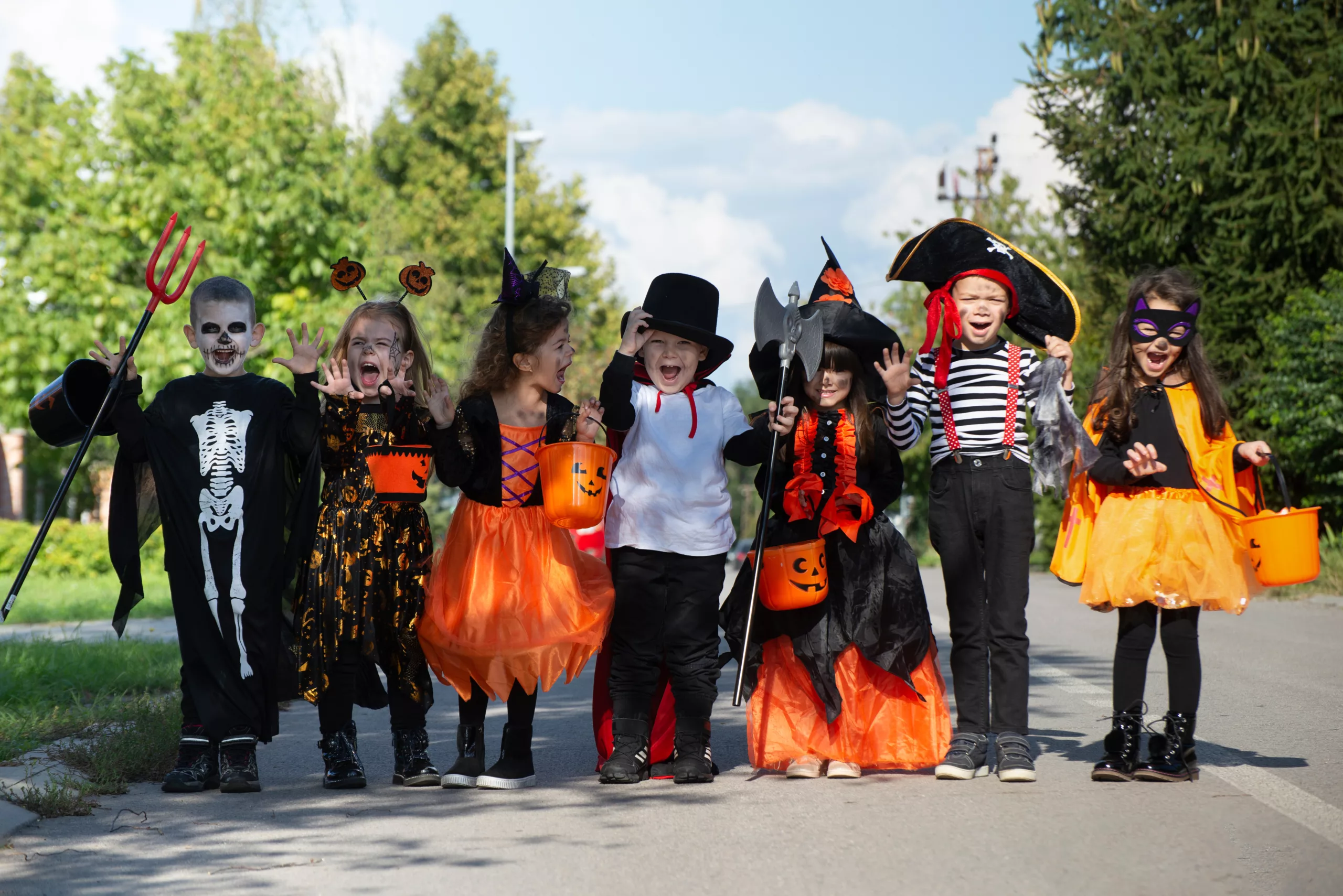 kids trick or treating in their neighborhood wearing Halloween costumes